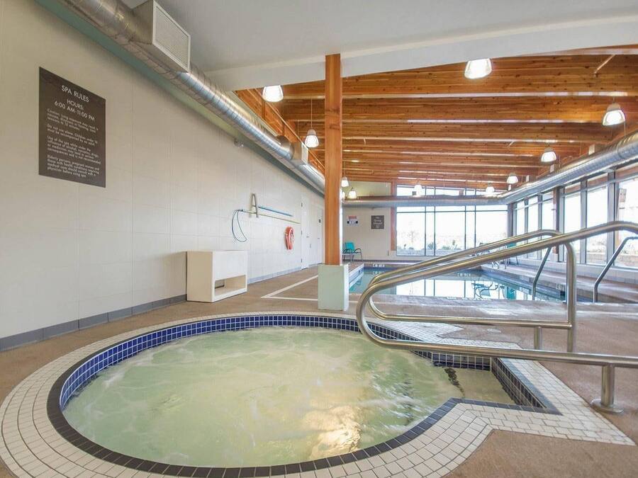 Et wellnessområde med jacuzzi, træbjælker i loftet og et skilt med spa-regler.