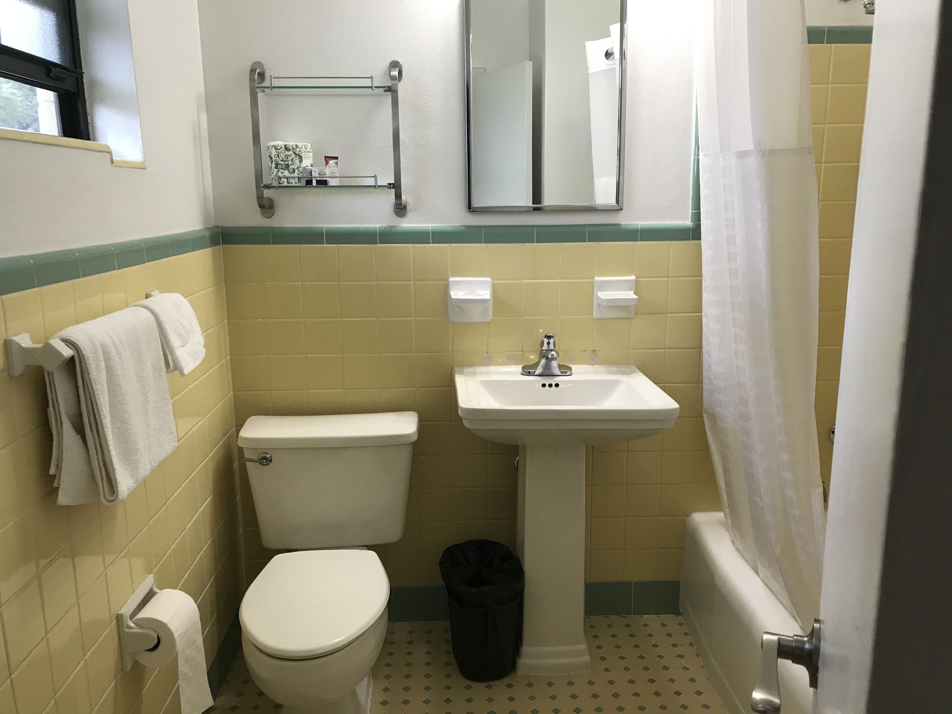 A bathroom with a toilet, sink, and shower curtain.