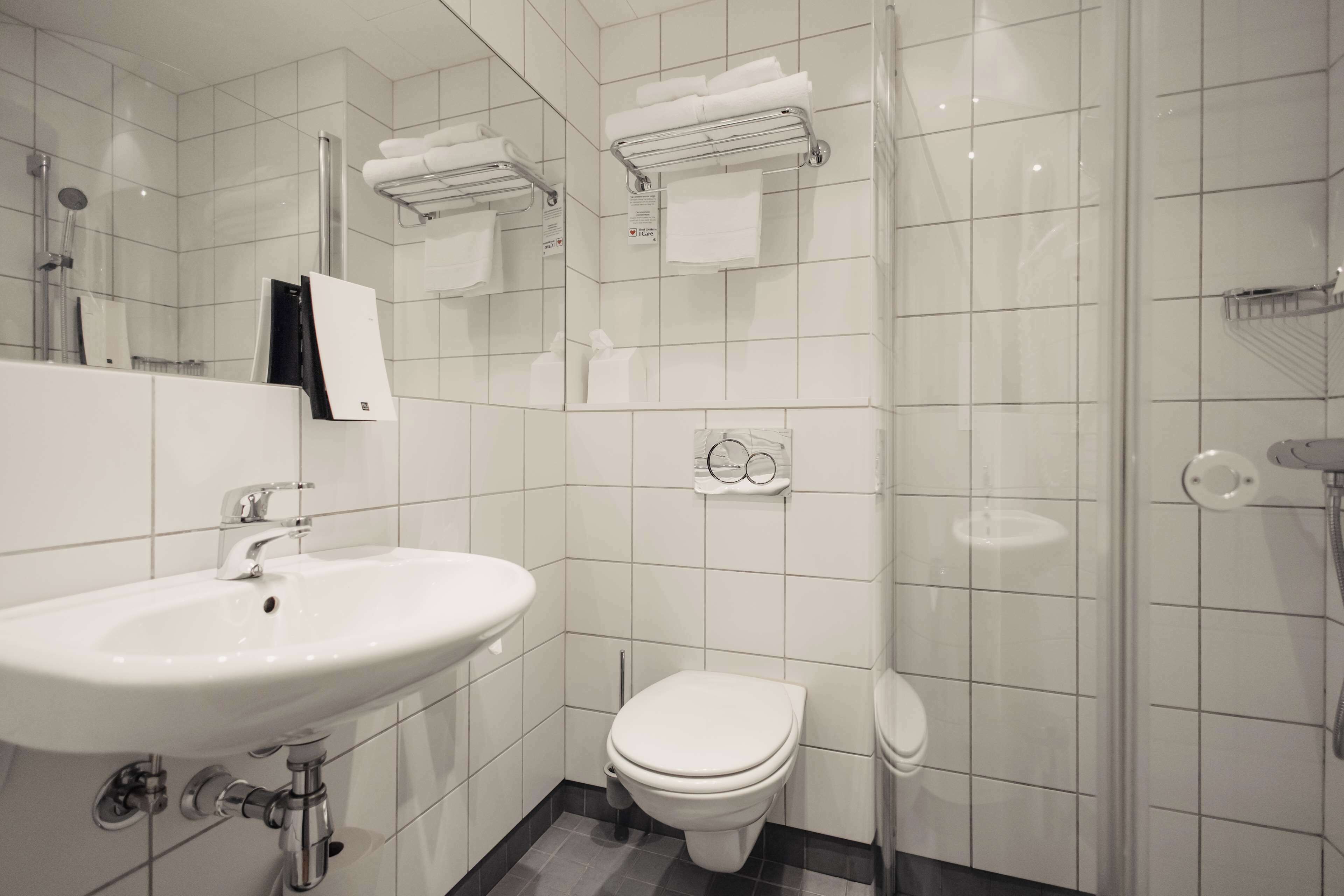 Une salle de bain moderne équipée d’un lavabo, de toilettes et d’une zone douche.