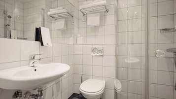 Une salle de bain moderne équipée d’un lavabo, de toilettes et d’une zone douche.