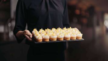 Una persona sostiene una bandeja con varios cupcakes.