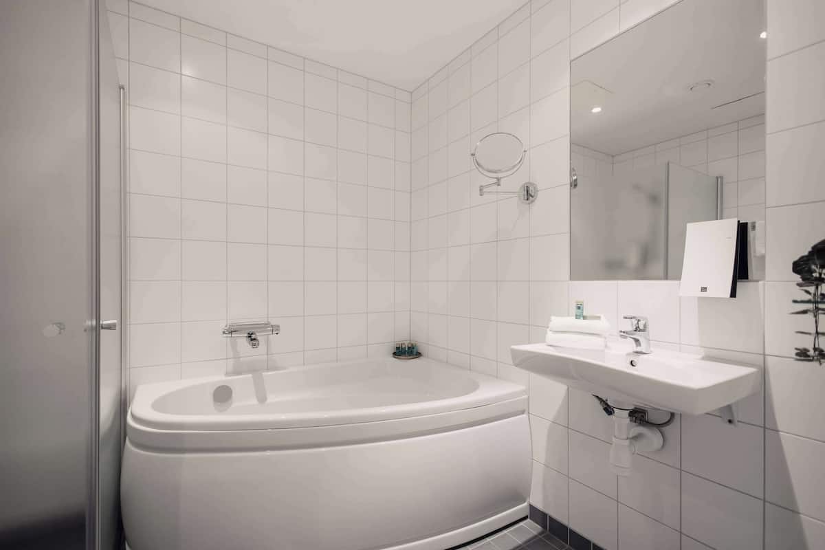 junior suite, 1 king bed, bathtub, sea view (living room) | bathroom | shower, hair dryer, towels