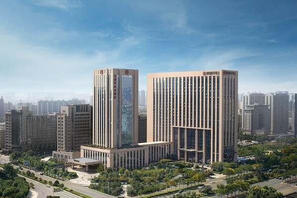 A high-rise building complex with multiple office towers, surrounded by greenery and a clear sky. - Sheraton Grand Zhengzhou Hotel (Zhengzhou)