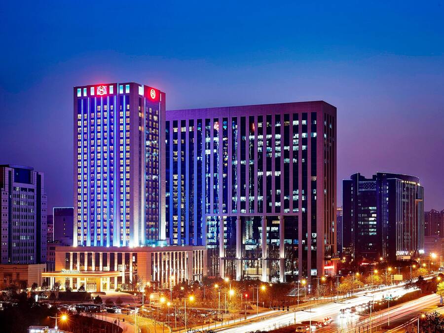 A high-rise hotel with multiple floors, a prominent sign at the top, and a well-lit facade.