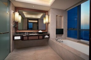 A modern bathroom with a large mirror, a bathtub, and a vanity with a sink and towel rack. - Sheraton Grand Zhengzhou Hotel (Zhengzhou)