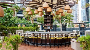 A rooftop bar with a circular seating area, a central bar, and hanging wicker lamps. - Taj Dubai (Dubai)