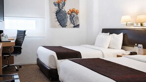 A hotel room with two beds, a desk, a chair, a lamp, and a cactus artwork on the wall. - Hotel VM Express Querétaro (Querétaro)
