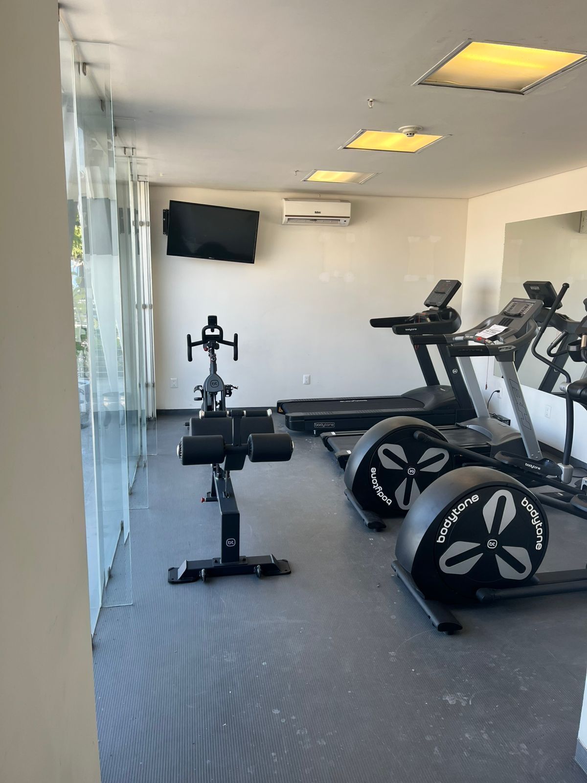 Un gimnasio con cintas de correr, una bicicleta estática y máquinas de pesas.