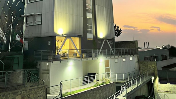 A modern building with a prominent 'VM' sign, multiple windows, and a staircase leading to an upper level. - Hotel VM Express Querétaro (Querétaro)