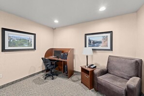 A hotel room with a desk, chair, sofa, lamp, and two framed pictures on the walls. - MainStay Suites Spokane Valley (Spokane Valley)