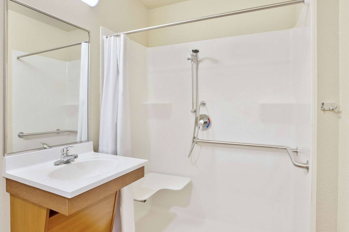 Ein Badezimmer mit Waschbecken, Spiegel und Dusche.