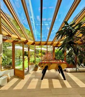 Una habitación con mesa de futbolín, ventanas amplias y vistas al exterior.