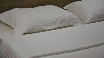 A bed with white bedding and a wooden headboard.