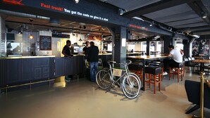 A modern cafe with a bar area, seating, and a bicycle.