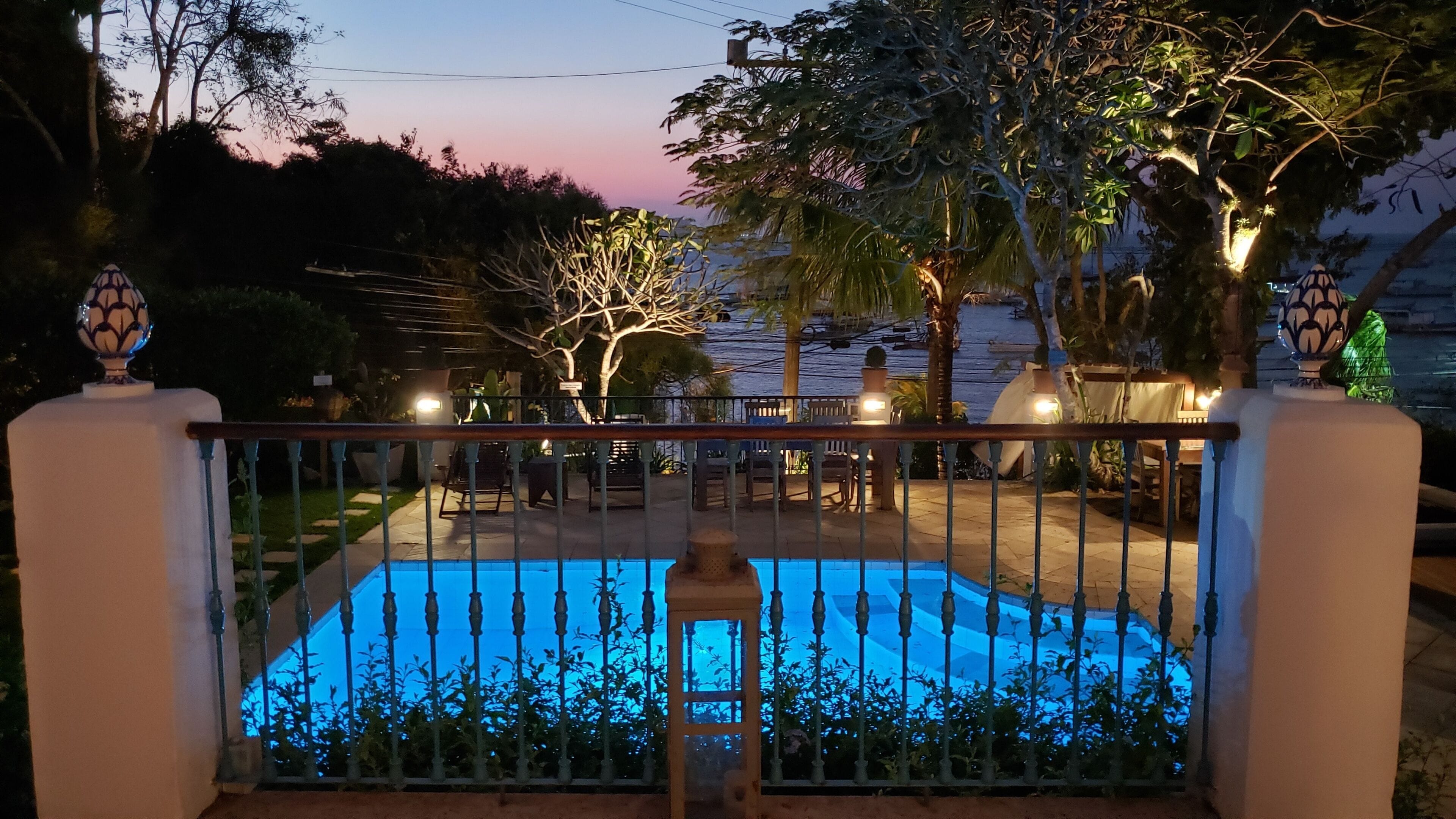 Una piscina al aire libre, sombrillas, sillones reclinables de piscina