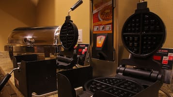 A waffle iron and a waffle maker on a countertop.