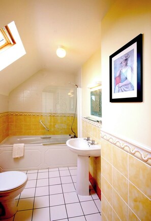 A bathroom with a bathtub, toilet, and sink.