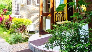A two-story building with a brick facade, large windows, and a yellow door. - Pousada Casa da Praia (Búzios)