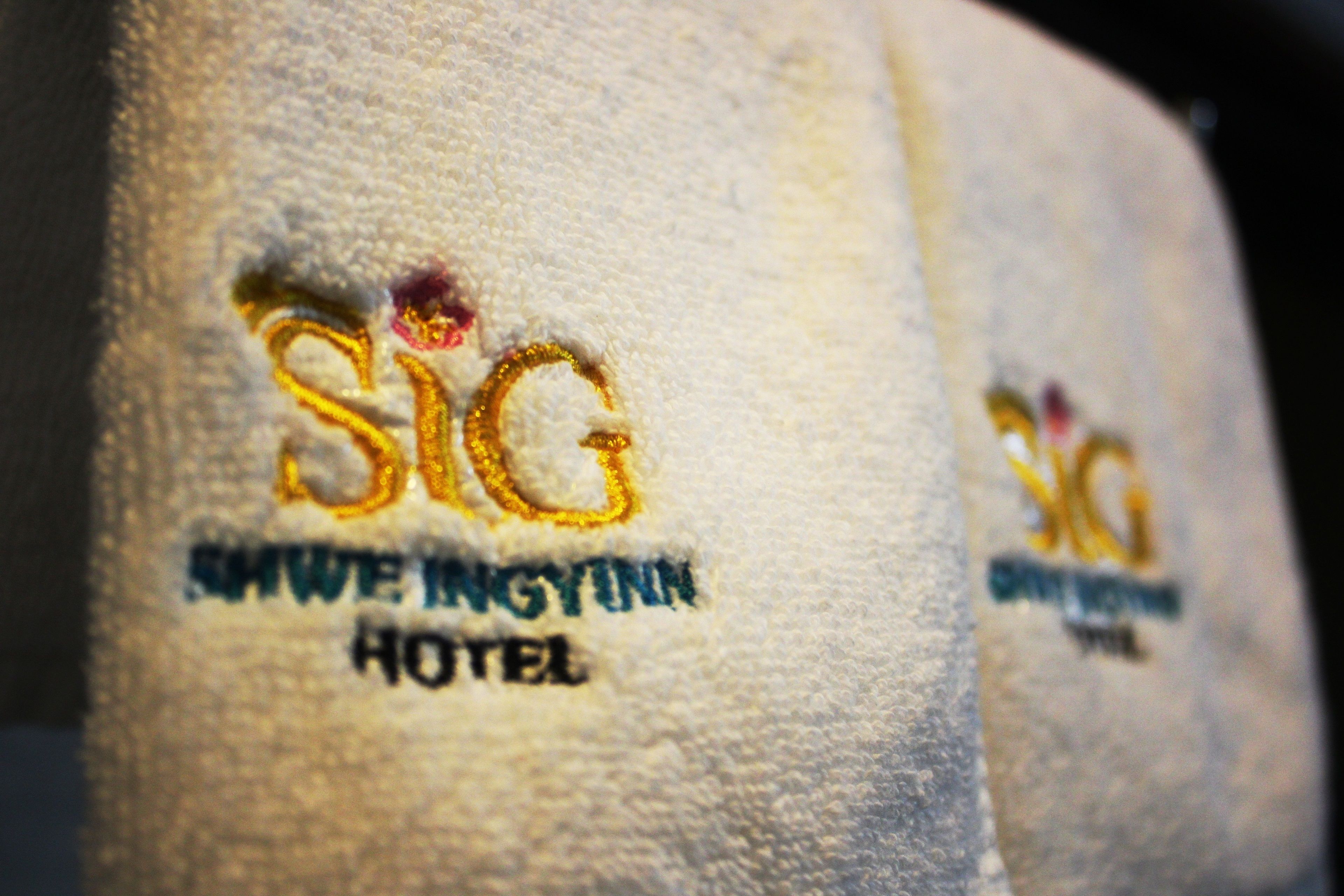 Primer plano de una toalla con bordado que dice "SIG" y "Hotel".