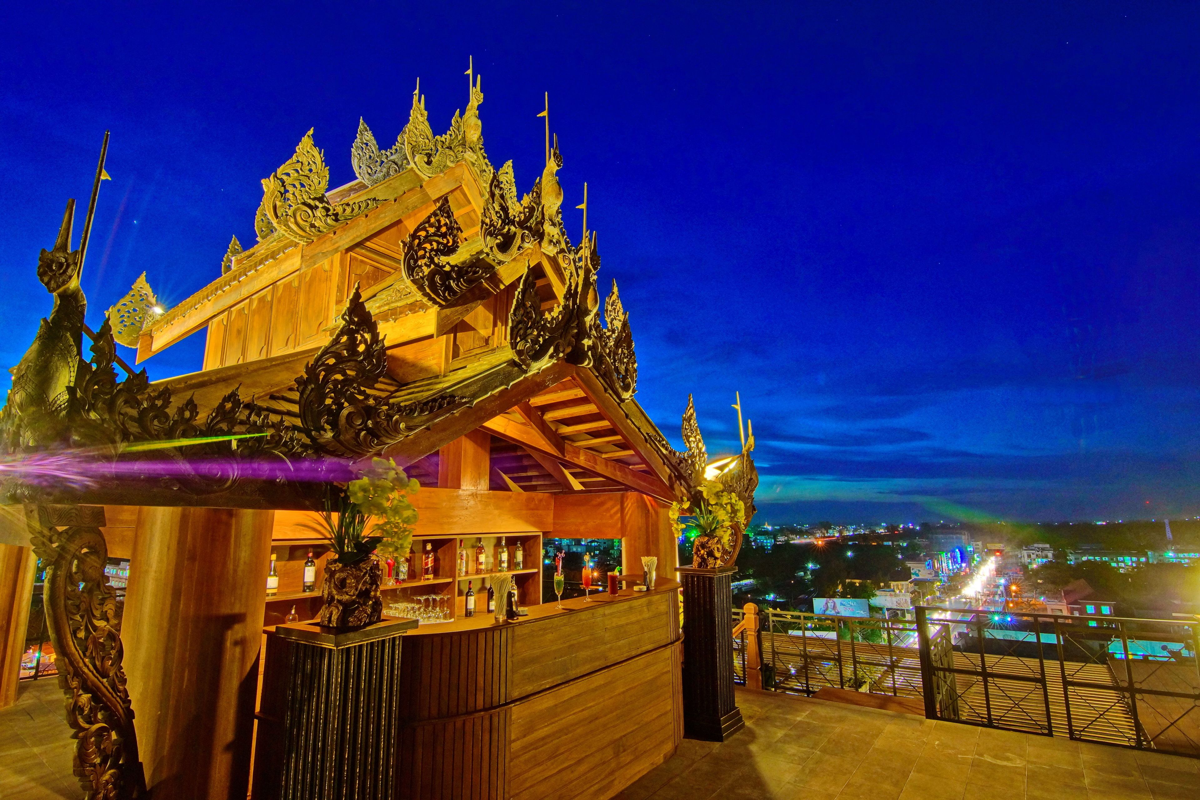 A traditional wooden structure with ornate carvings and a golden roof, likely a cultural or historical building.
