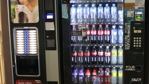 Un distributeur automatique équipé d’un appareil à café et d’un espace proposant un choix de boissons.
