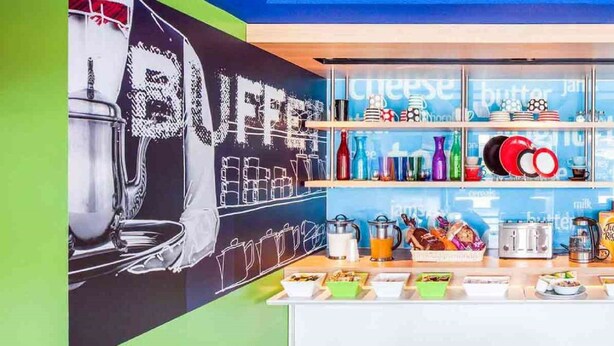 Un buffet de petit-déjeuner proposant une variété d’aliments et de boissons, notamment des céréales en boîte et une machine à café.