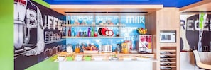 Una barra de desayuno con diversos alimentos y bebidas, incluyendo cajas de cereal y una máquina de café.