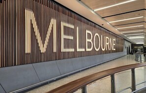 Een modern interieur met een opvallend 'MELBOURNE' bord op een houten wand.