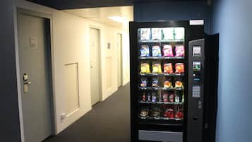 Um corredor com uma máquina de vendas abastecida com lanches e bebidas.
