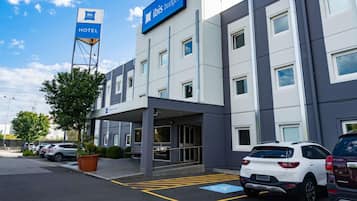 A modern hotel building with a sign indicating it is part of the ibis budget hotel chain.