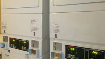 A row of stacked front-loading washing machines with digital displays and control panels.