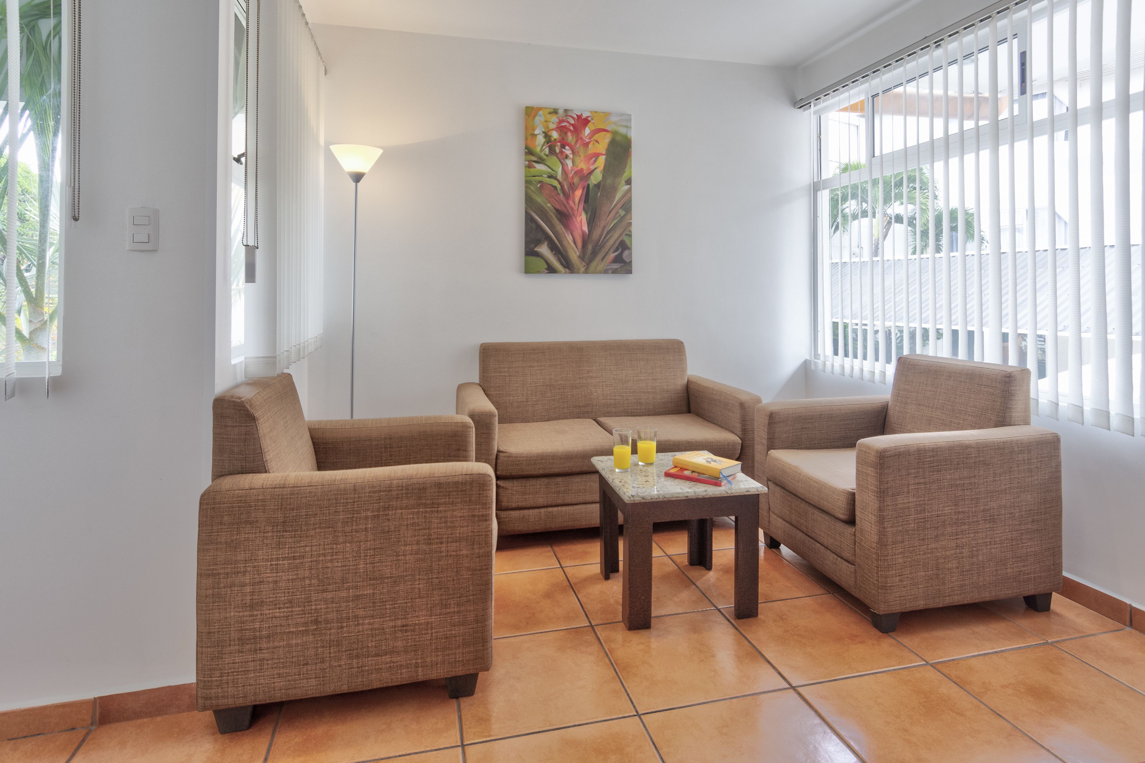 A living room with two sofas, a coffee table, and a painting on the wall.