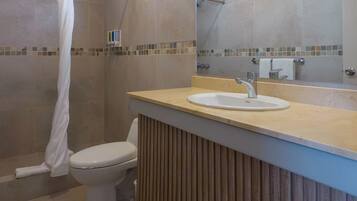 Un baño con inodoro, lavamanos y ducha.