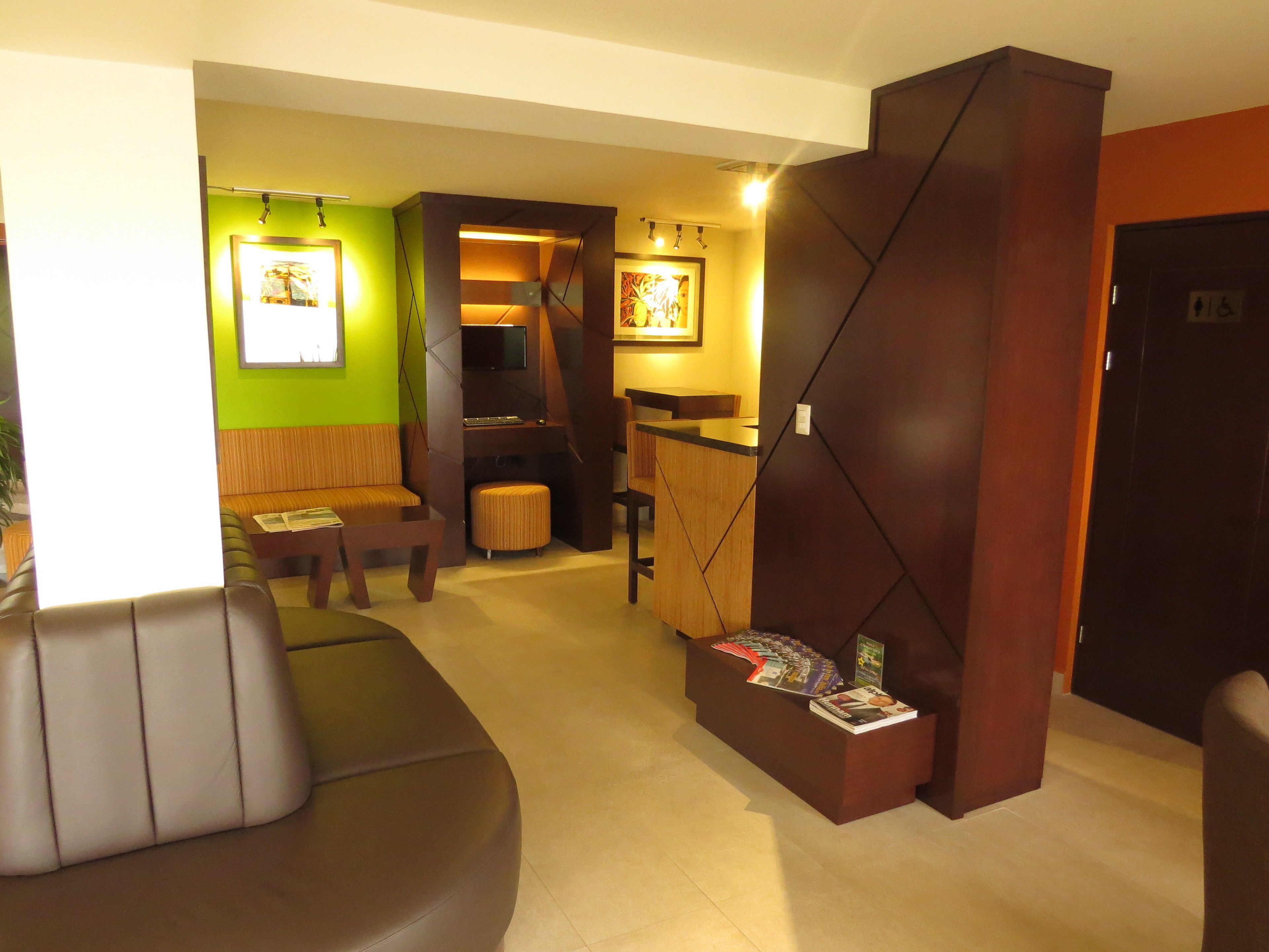 A modern lobby with a seating area, a reception desk, and a staircase.