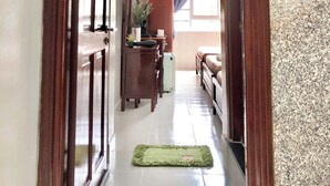 A hallway leading to a bedroom with a bed, a desk, and a chair. - Saigon Cozy2 Hotel (Ho Chi Minh City)