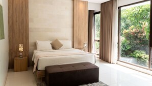 Une chambre moderne avec un grand lit, une table de chevet, une lampe de lecture et une vue sur la verdure grâce à une porte coulissante.