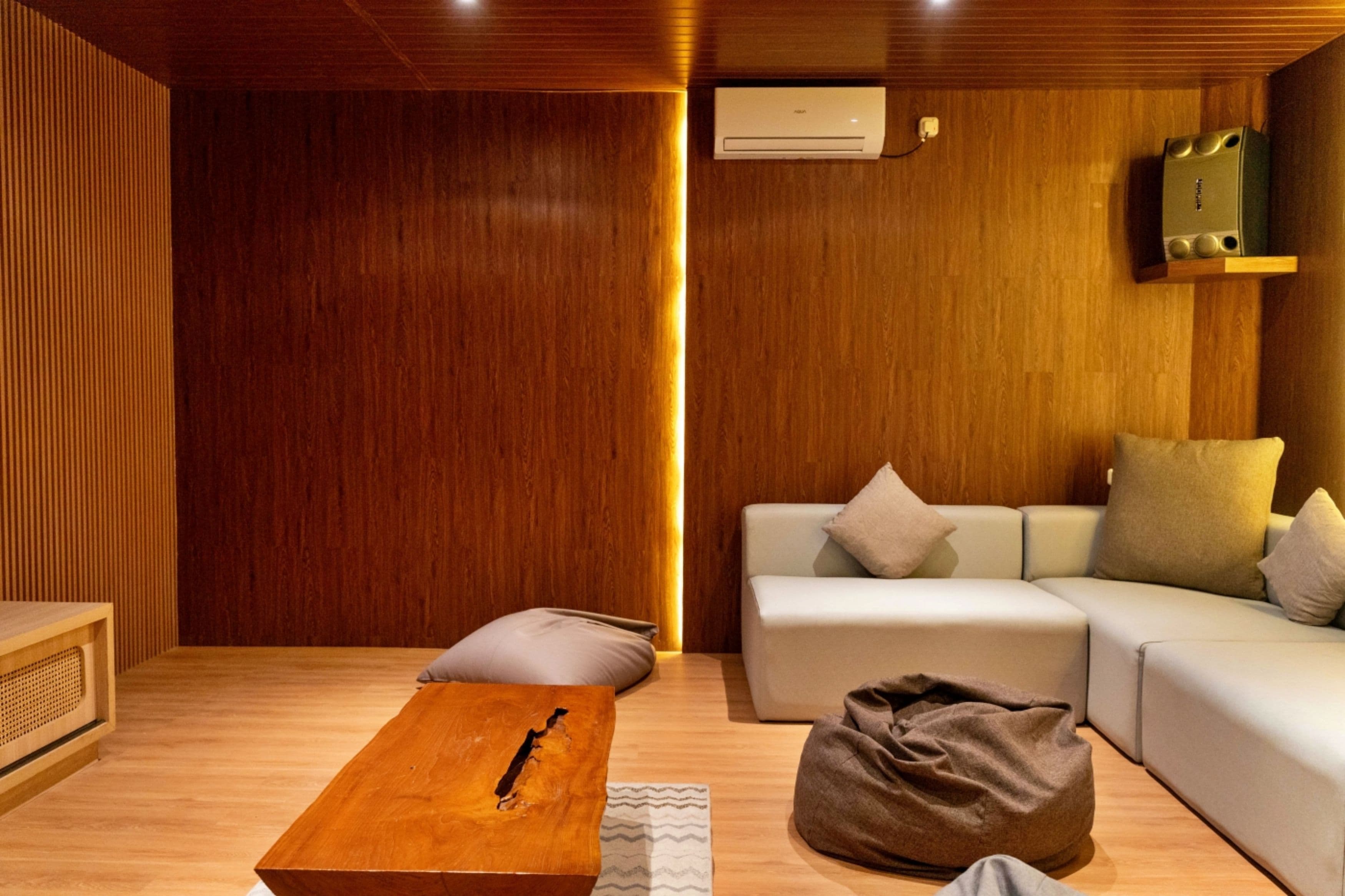 A modern living room with a wooden floor, a sofa set, a coffee table, and a bag.