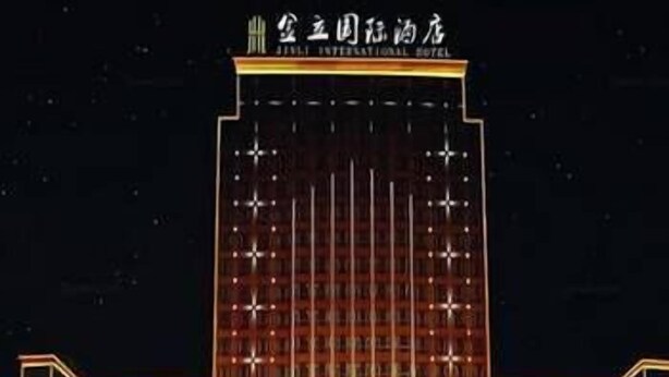 Un hotel de varios pisos con un diseño moderno, que destaca un letrero grande en la parte superior.