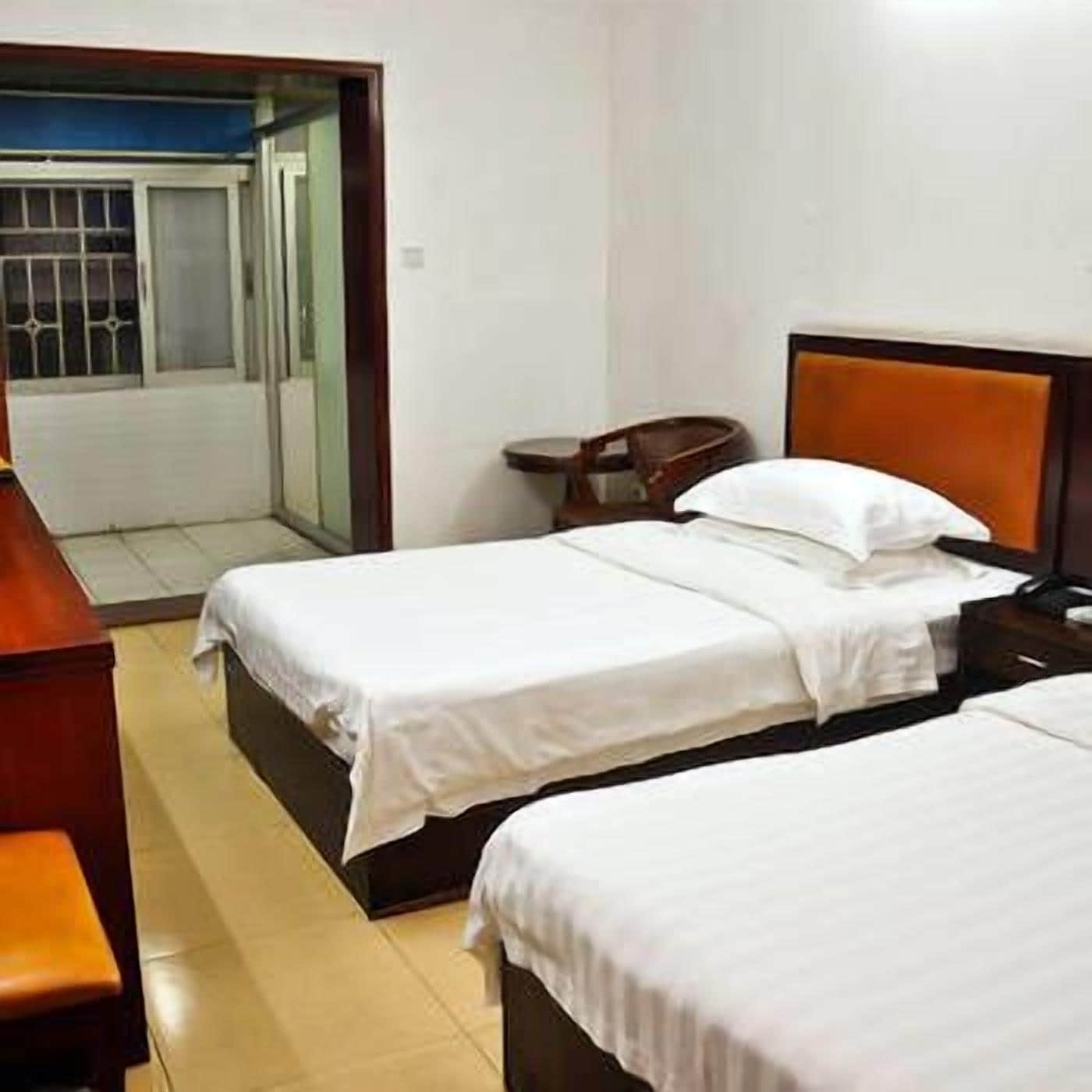 Habitación de hotel con dos camas, un escritorio y una silla.