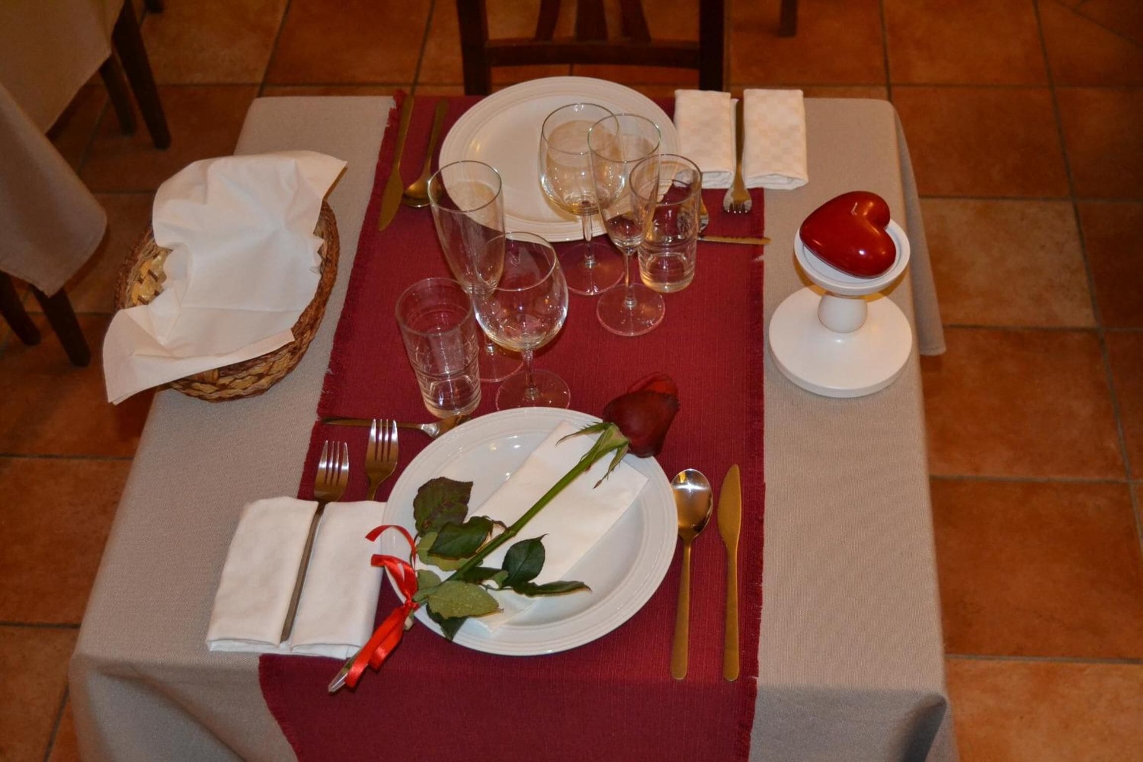 Uma mesa posta para refeição, com pratos, copos e talheres.