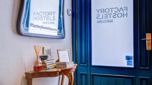 Una pared con dos letreros que anuncian 'FACTORY HOSTELS' y 'FACTORY HOSTELS 2.0' en Barcelona.