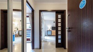 A hotel room with a wooden door, a view of the hallway, and a sign on the wall. - Tatrytop Apartamenty Tetmajer (Zakopane)
