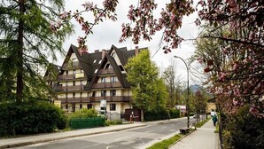 A two-story building with a traditional architectural style, featuring a steeply pitched roof and a symmetrical facade. - Tatrytop Apartamenty Tetmajer (Zakopane)
