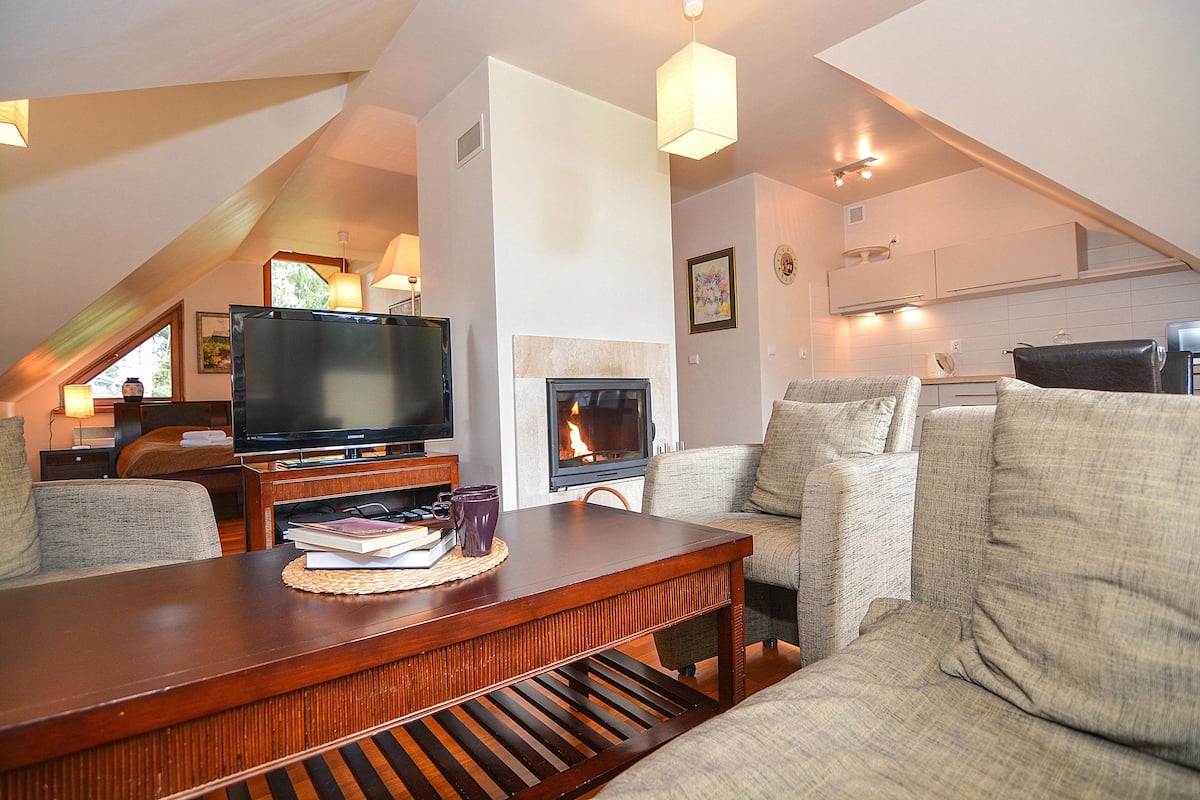 A cozy living room with a fireplace, a television, and comfortable seating.