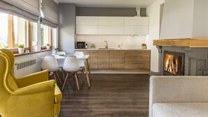 A modern kitchen with wooden cabinets, a built-in microwave, and a fireplace.