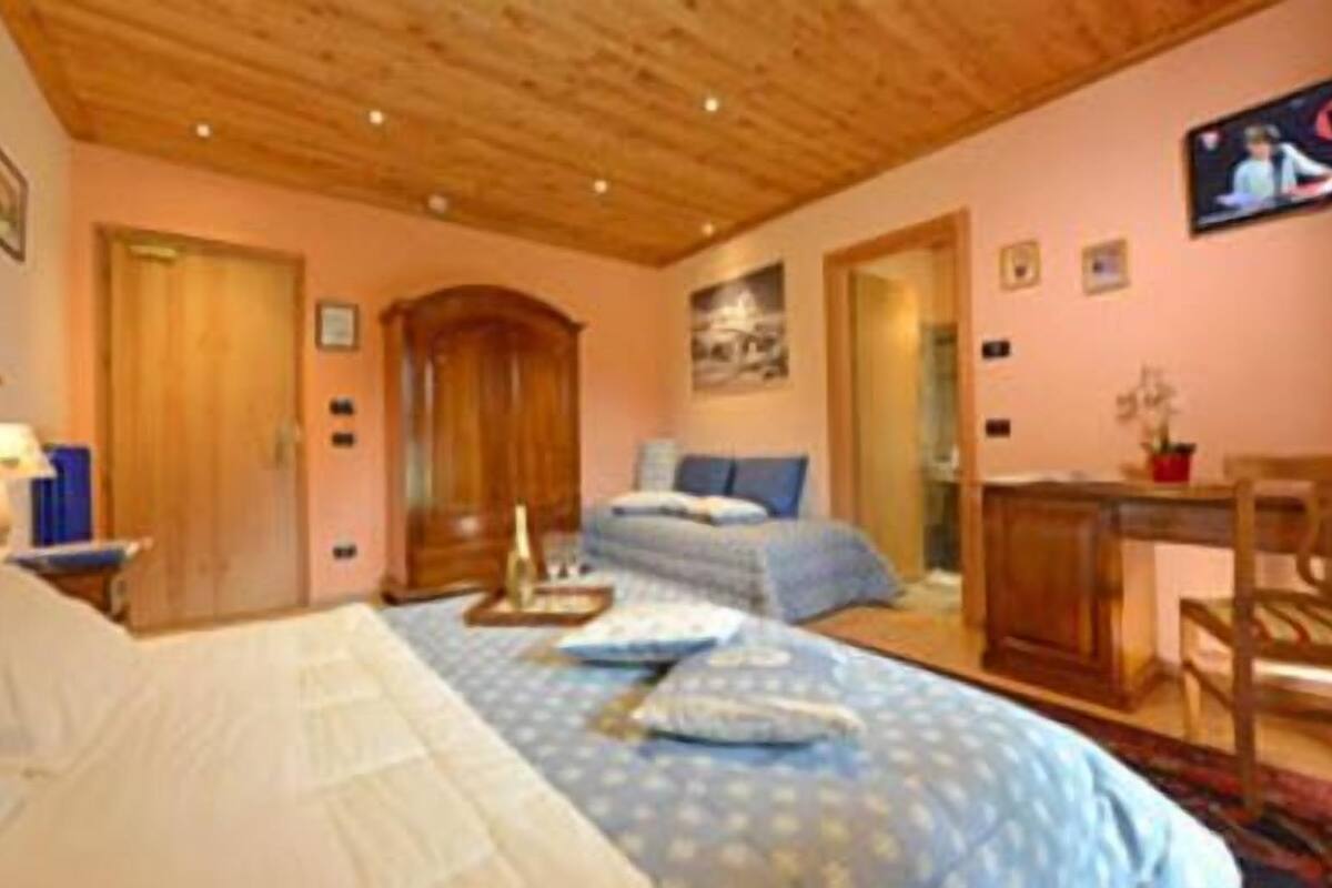 Une chambre avec un plafond en bois, un lit avec une literie bleue, un bureau et une chaise.
