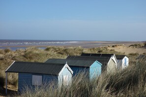 A row of beach huts with a view of the sea. - Caley Hall (Hunstanton)