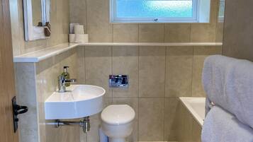 A modern bathroom with a toilet, sink, and bathtub.