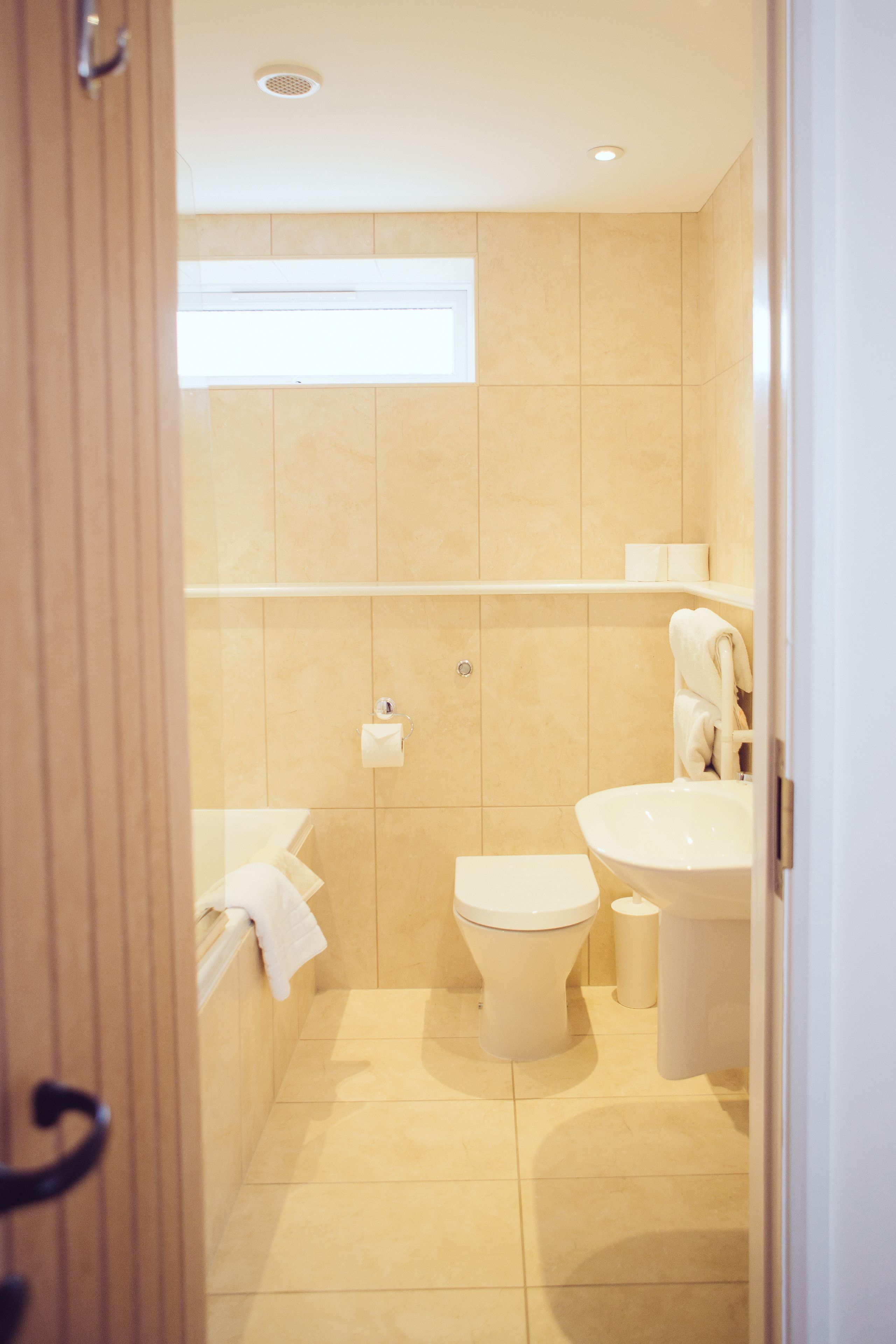 A modern bathroom with a toilet, sink, and shower area.