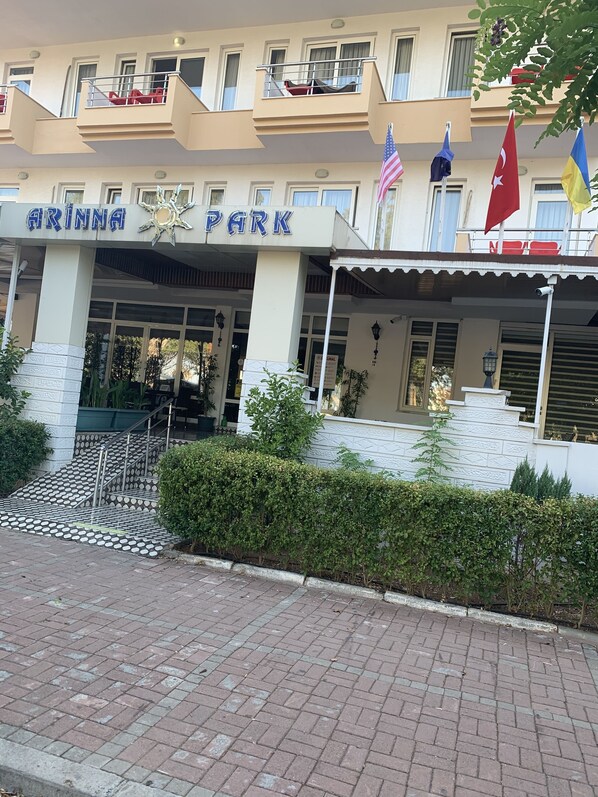 Un bâtiment portant l’enseigne « Arinna Park » et arborant plusieurs drapeaux, dont le drapeau américain.